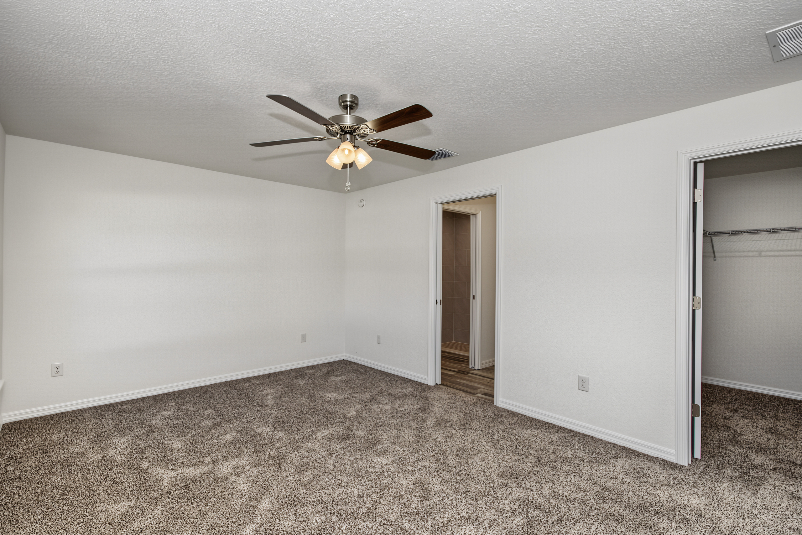 Bedroom interior looking toward bathroom and open walk-in closet